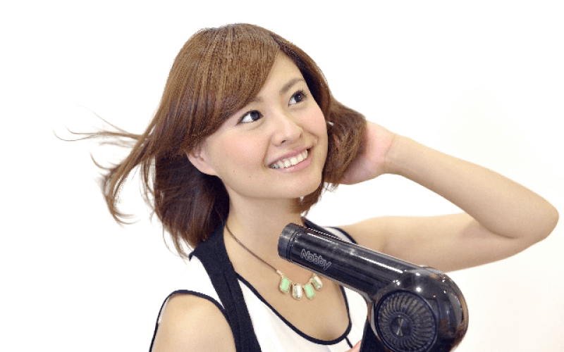 ドライヤーをかける女性